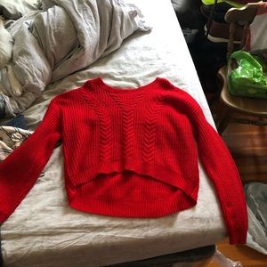 Very red sweater. Laced design on the top of the back (serves no purpose)